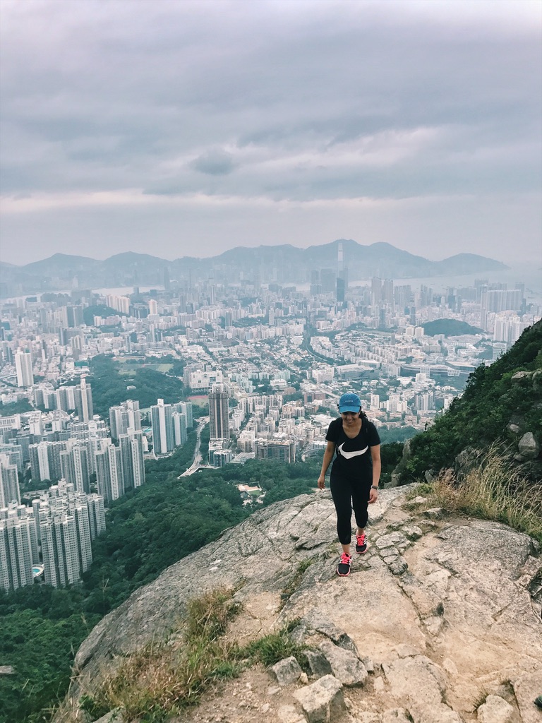 Amrita hiking up Lion Rock, with the Kowloon skyline and Hong Kong harbour below